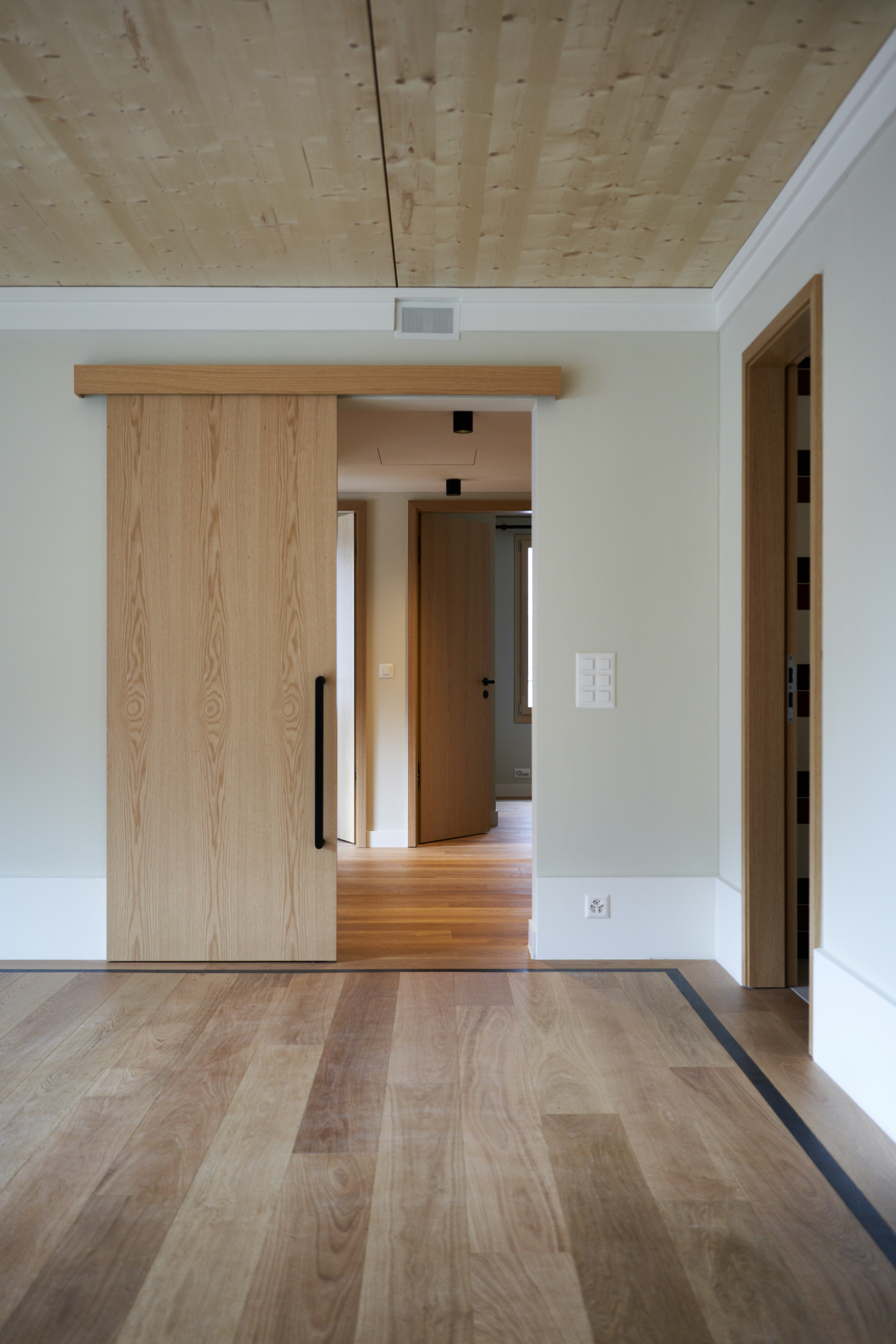 pièce vide avec porte en bois et plancher de bois franc, décor neutre